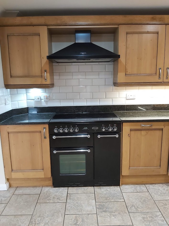 Oak kitchen with white tiles and black double oven