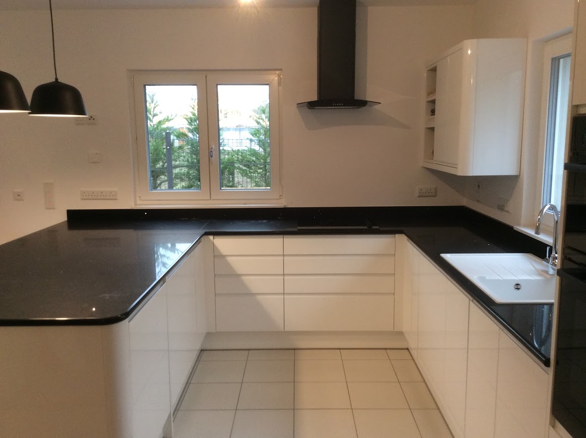 U shaped white handless kitchen with black worktops