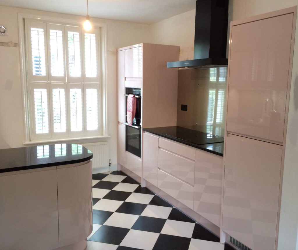 Pink fitted kitchen with black granite worktops