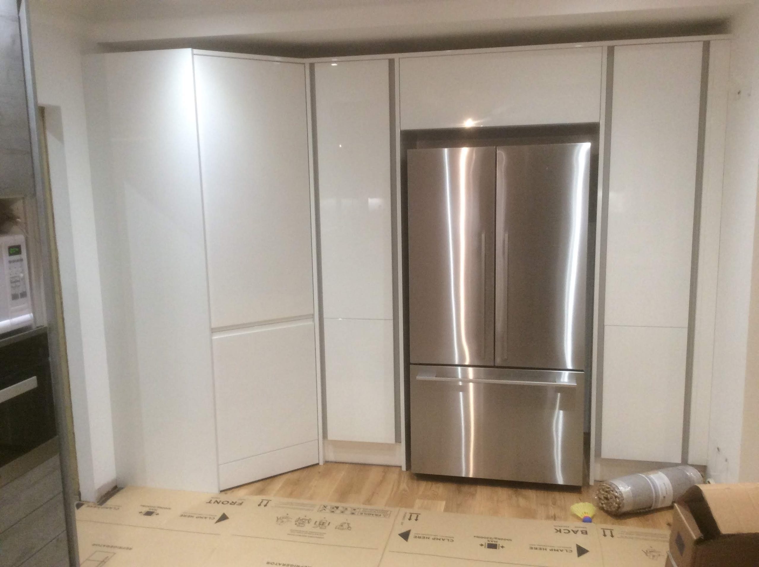 Tall white kitchen units and American fridge freezer